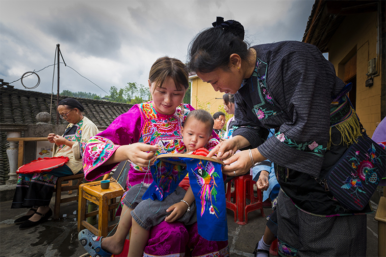 Miao Xiu state-level inheritors guide embroidered mothers to embroider.